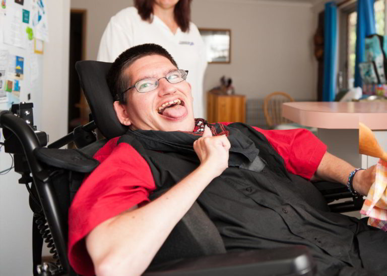 Disabled man reclining in his wheelchair smiling